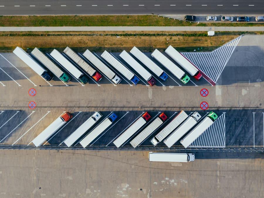 A fleet of trucks parked in rows at a distribution yard